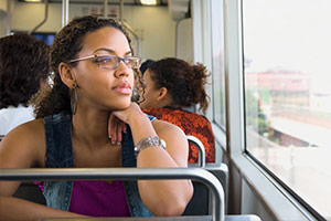 A female domestic violence victim is on the bus staring blankly into the distance.