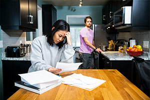 A couple suffering from financial hardship are in their home reviewing bills. A couple suffering from financial hardship are in their home reviewing bills.